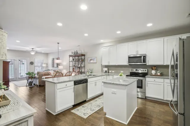a kitchen with granite countertop white cabinets and stainless steel appliances