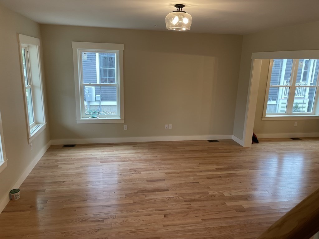 3 Powell Street, Unit B Devens, MA 01434 - Photo 7 of 28 an empty room with wooden floor and windows