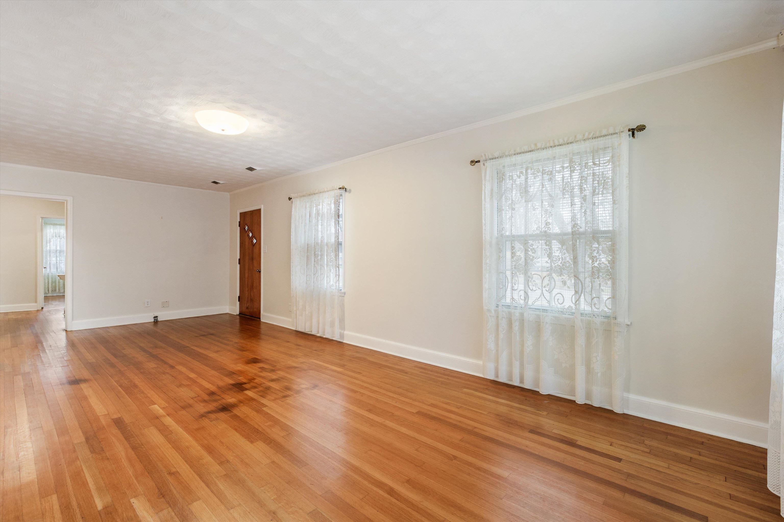 1217 Vaughn Road Memphis, TN 38122 - Photo 8 of 27 an empty room with wooden floor and windows