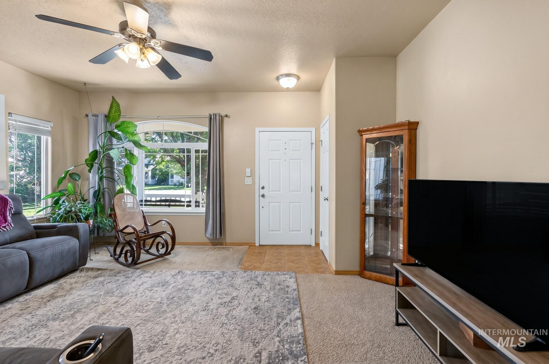 5020 Northrup Way Caldwell, ID 83607 - Photo 6 of 36 Living area featuring a textured ceiling, a ceiling fan with integrated lighting, and neutral wall tones