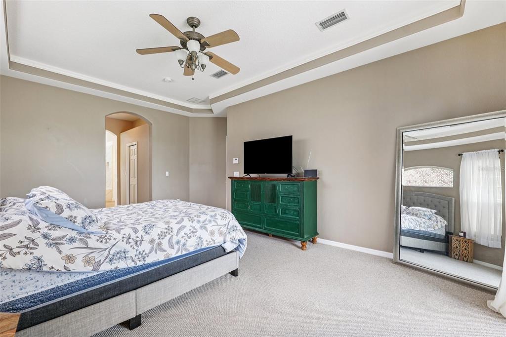 13049 Thoroughbred Drive Dade City, FL 33525 - Photo 25 of 52 a bedroom with a bed and a flat screen tv