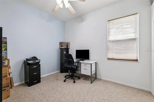 a view of a workspace with furniture and a window