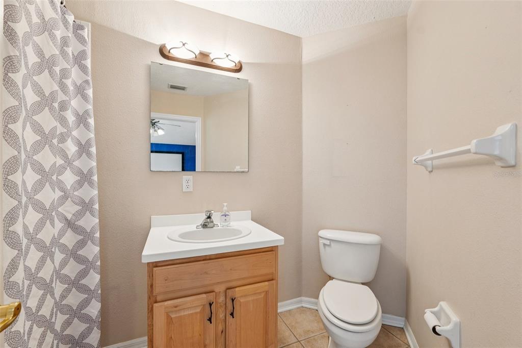 13049 Thoroughbred Drive Dade City, FL 33525 - Photo 32 of 52 a bathroom with a toilet a sink and mirror
