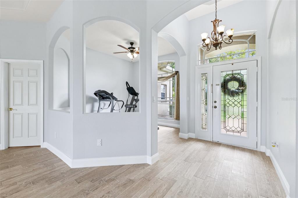 13049 Thoroughbred Drive Dade City, FL 33525 - Photo 6 of 52 a view of a hallway view with wooden floor and chandelier
