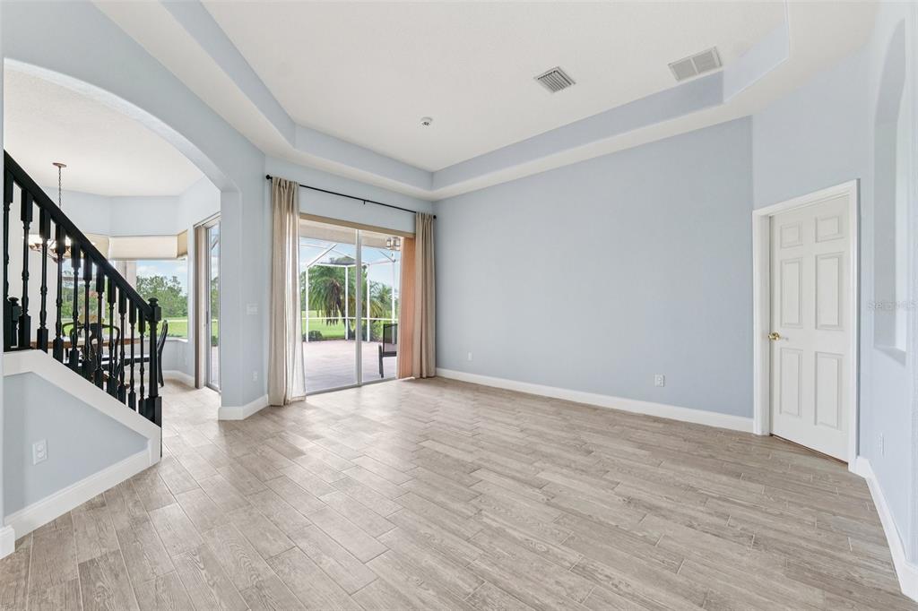 13049 Thoroughbred Drive Dade City, FL 33525 - Photo 8 of 52 an empty room with wooden floor and windows