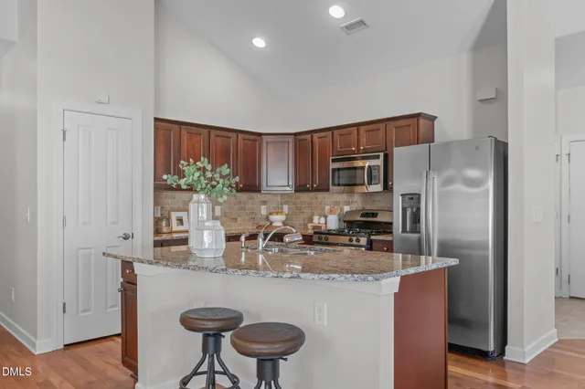 a kitchen with granite countertop a sink stove and refrigerator