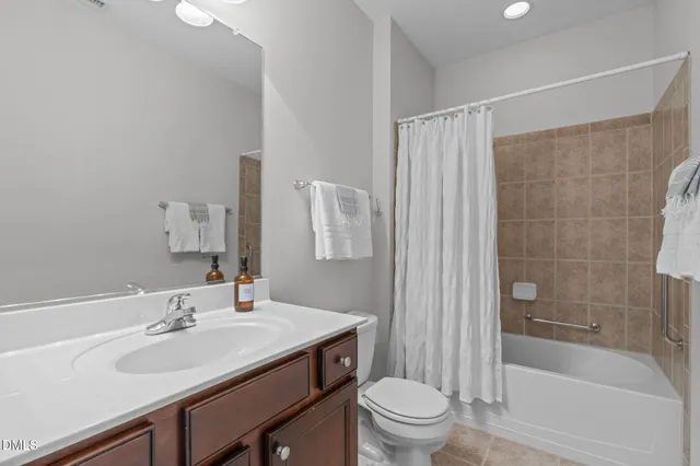 a bathroom with a toilet sink double vanity and mirror