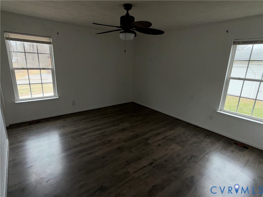 117 Pleasant Spring Avenue Waverly, VA 23890 - Photo 6 of 12 an empty room with wooden floor cabinet and windows