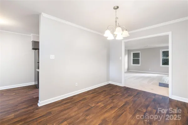 a view of a room with wooden floor and chandelier
