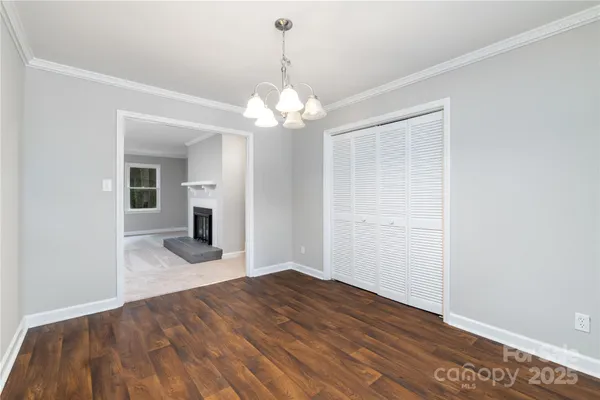 a view of empty room with wooden floor and ceiling fan