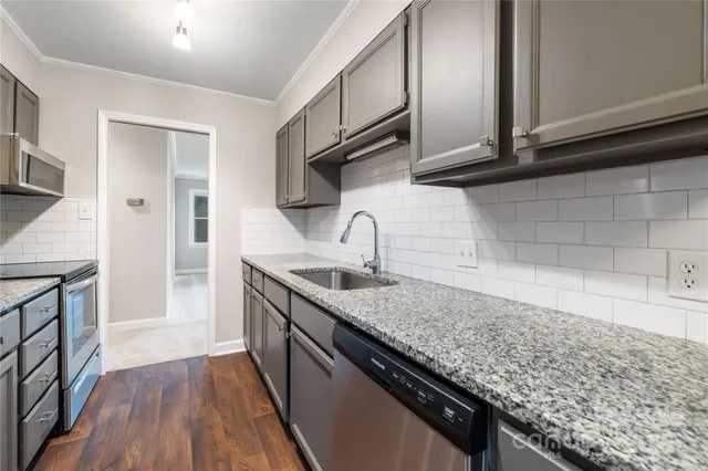 a kitchen with stainless steel appliances granite countertop a sink stove and cabinets