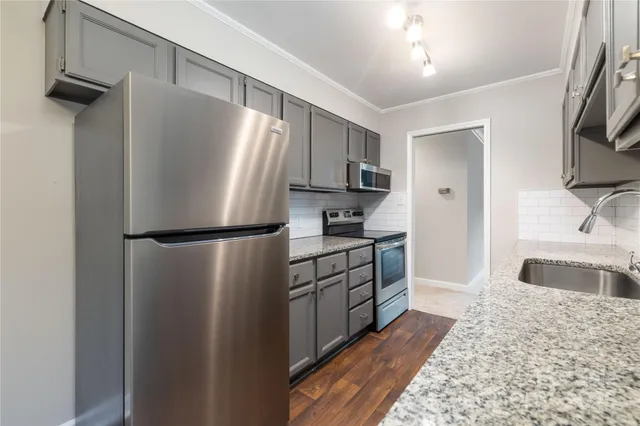 a kitchen with stainless steel appliances granite countertop a refrigerator and a sink