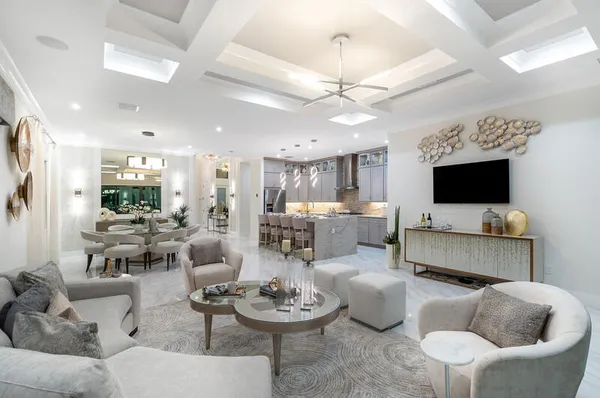 a living room with furniture a flat screen tv and kitchen view