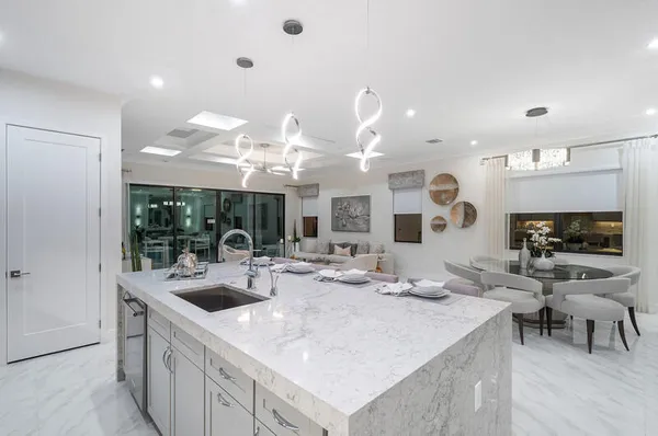 a kitchen with stainless steel appliances kitchen island granite countertop a sink and a large window