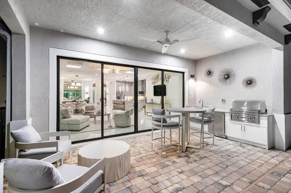 a living room with furniture a large window and stainless steel appliances