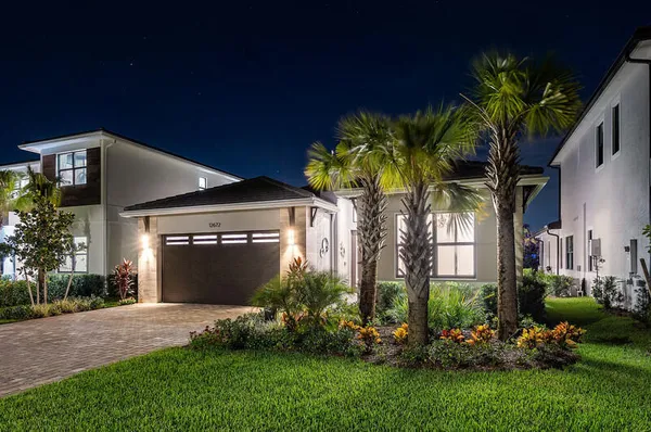 a front view of a house with a yard and potted plants