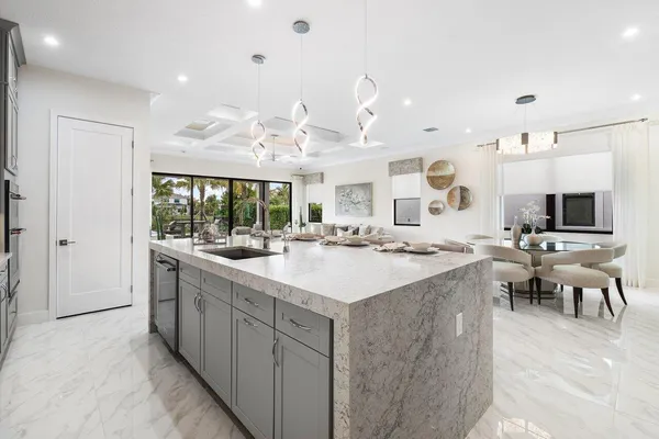 a large kitchen with kitchen island a sink table and chairs