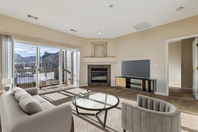 a living room with furniture a large window and a fireplace