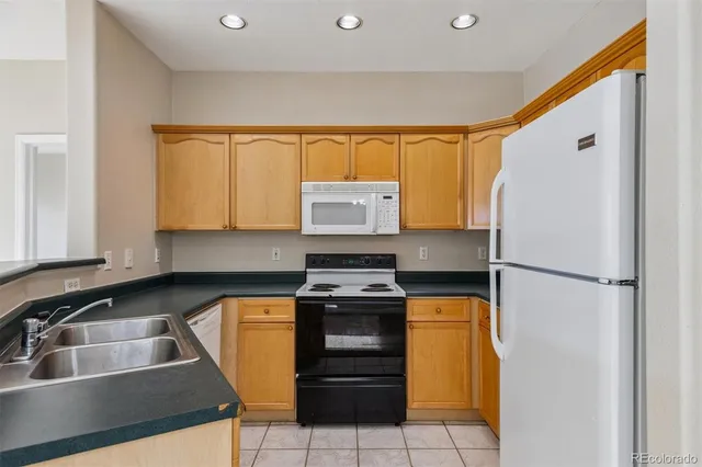a kitchen with a stove a refrigerator and a sink