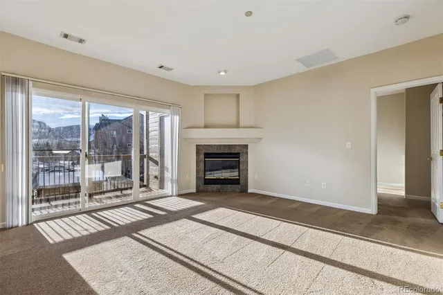 wooden floor fireplace and windows in an empty room