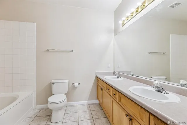 a bathroom with a granite countertop sink a toilet and bathtub