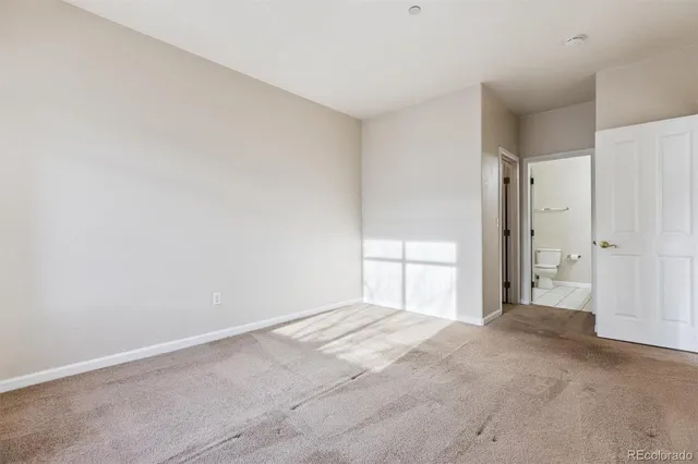 a view of an empty room with a fireplace and a window