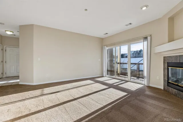 a view of an empty room with a fireplace and a window