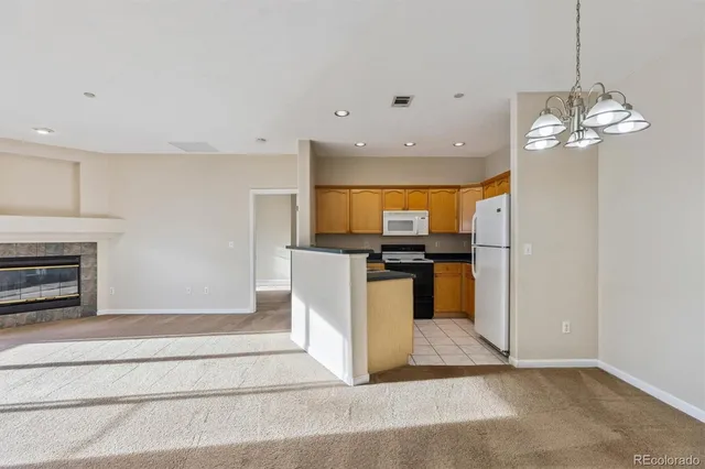 a view of a kitchen with granite countertop stainless steel appliances and a chandelier