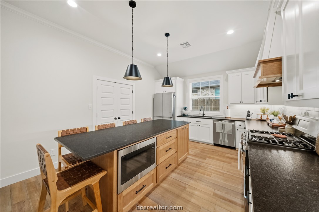 3520 Fairhope Way Bryan, TX 77808 - Photo 12 of 39 a kitchen with a stove a sink and chairs