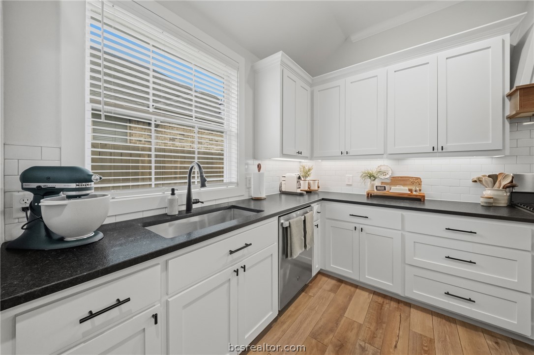 3520 Fairhope Way Bryan, TX 77808 - Photo 13 of 39 a kitchen with granite countertop a sink stainless steel appliances white cabinets and a window
