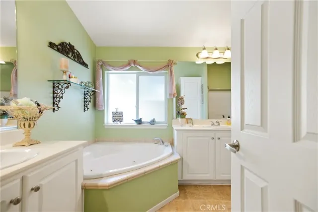 a bathroom with a tub sink and mirror