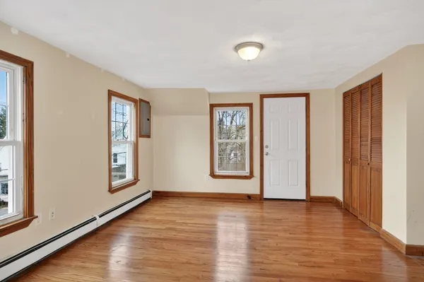 a view of an empty room with glass door and wooden floor