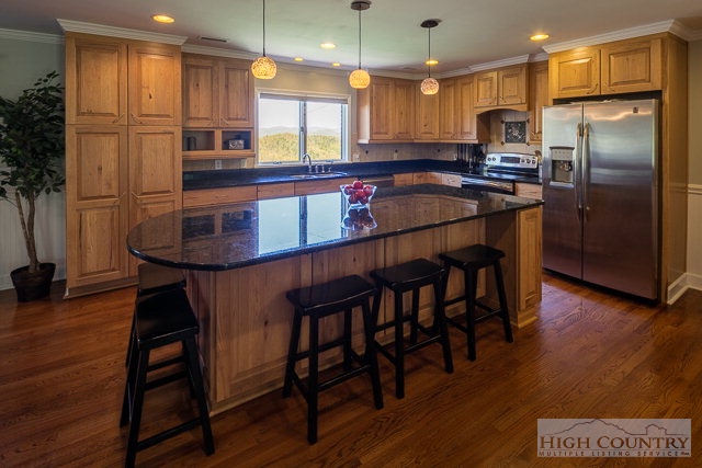 1762 Hidden Spring Road West Jefferson, NC 28694 - Photo 46 of 46 a kitchen with stainless steel appliances granite countertop a refrigerator a stove a sink a dining table and chairs with wooden floor