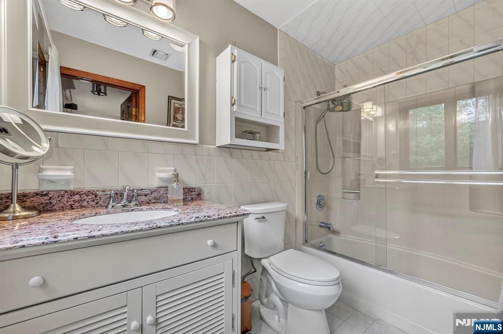 5110 Berkshire Valley Road Oak Ridge, NJ 07438 - Photo 31 of 49 a bathroom with a granite countertop sink toilet and shower