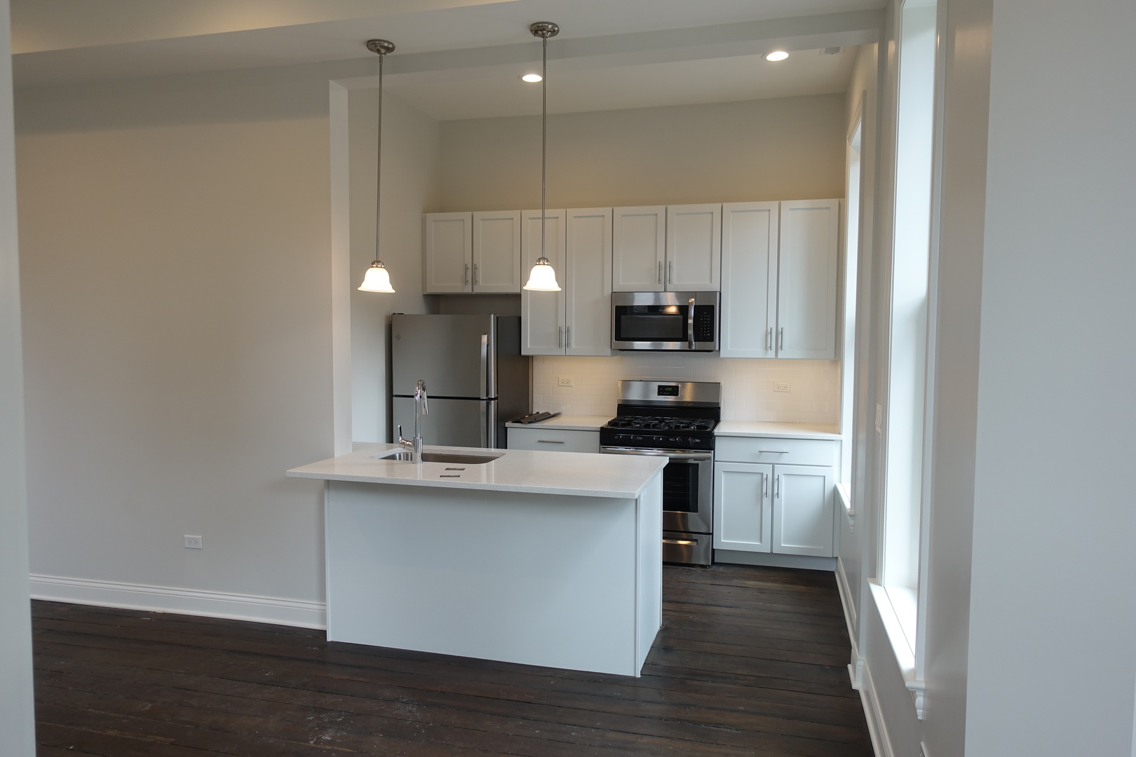 809 North Franklin Street, Unit 2F Chicago, IL 60610 - Photo 2 of 14 a kitchen with kitchen island a sink stainless steel appliances and cabinets