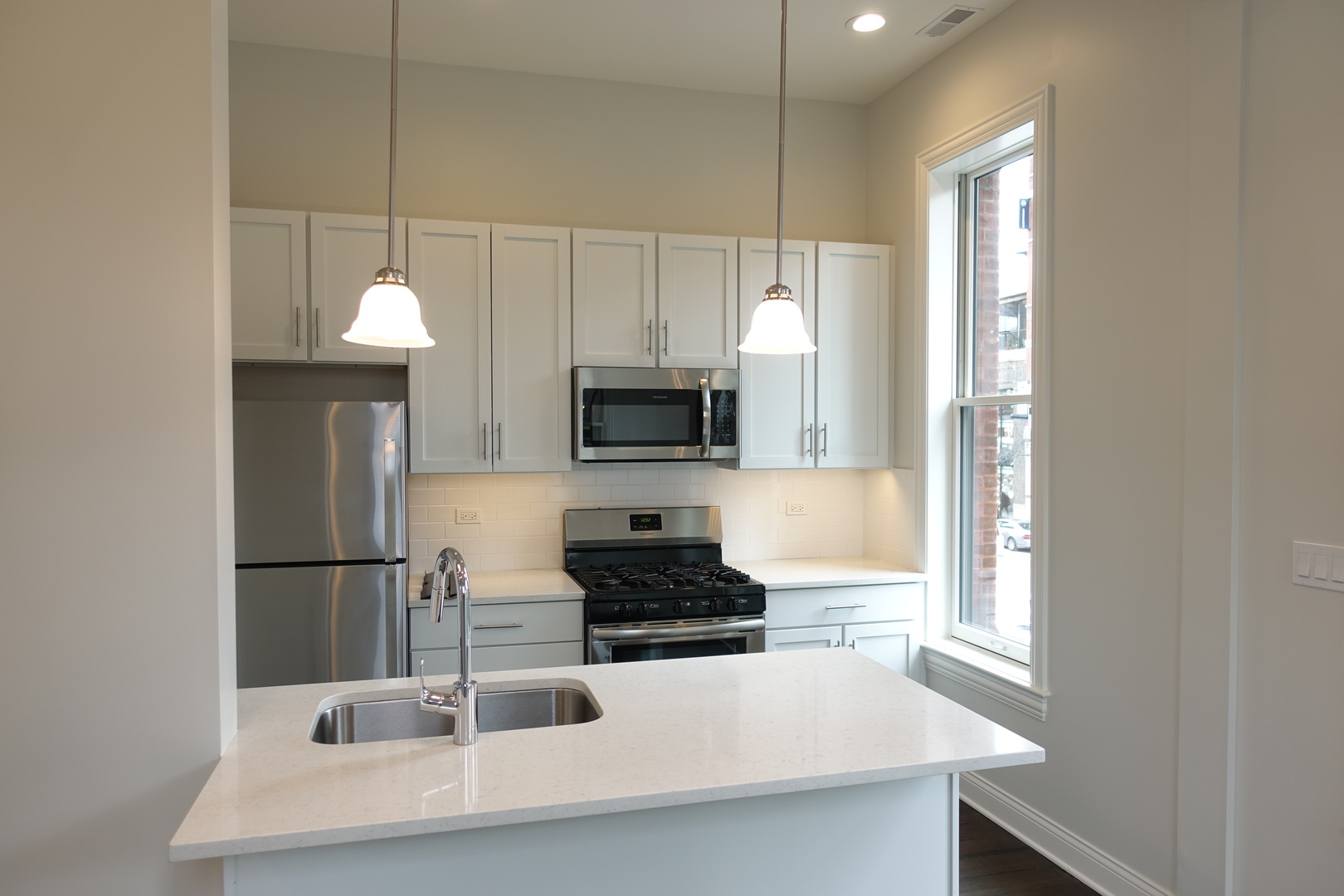 809 North Franklin Street, Unit 2F Chicago, IL 60610 - Photo 4 of 14 a kitchen with a sink a microwave a stove and refrigerator