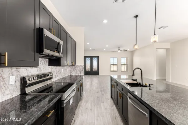 a kitchen with granite countertop a stove and a sink