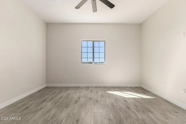 an empty room with wooden floor and windows