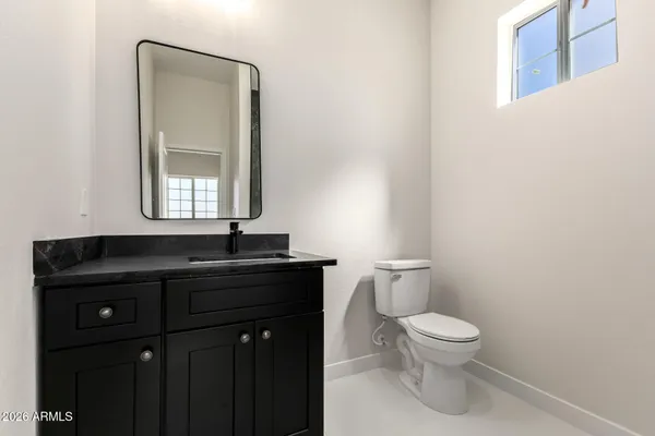 a bathroom with a toilet sink vanity and mirror