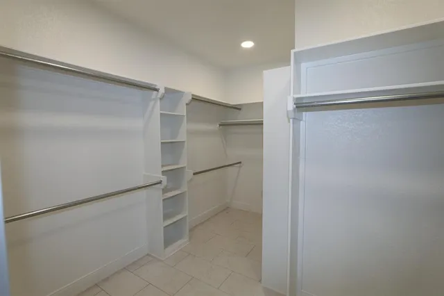 a view of walk in closet with empty racks