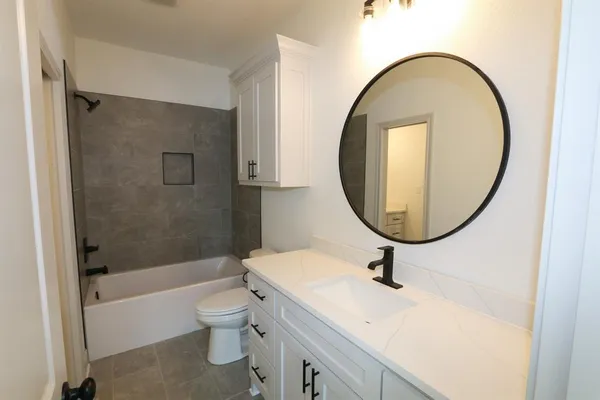 a bathroom with a sink a toilet and a mirror