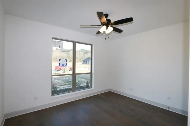 an empty room with windows and fan