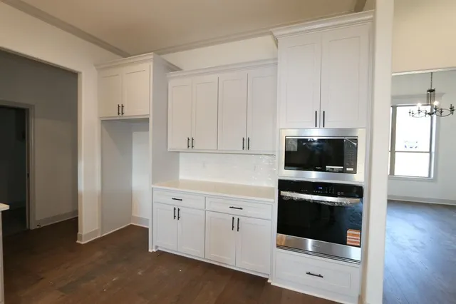 a kitchen with white cabinets and white appliances