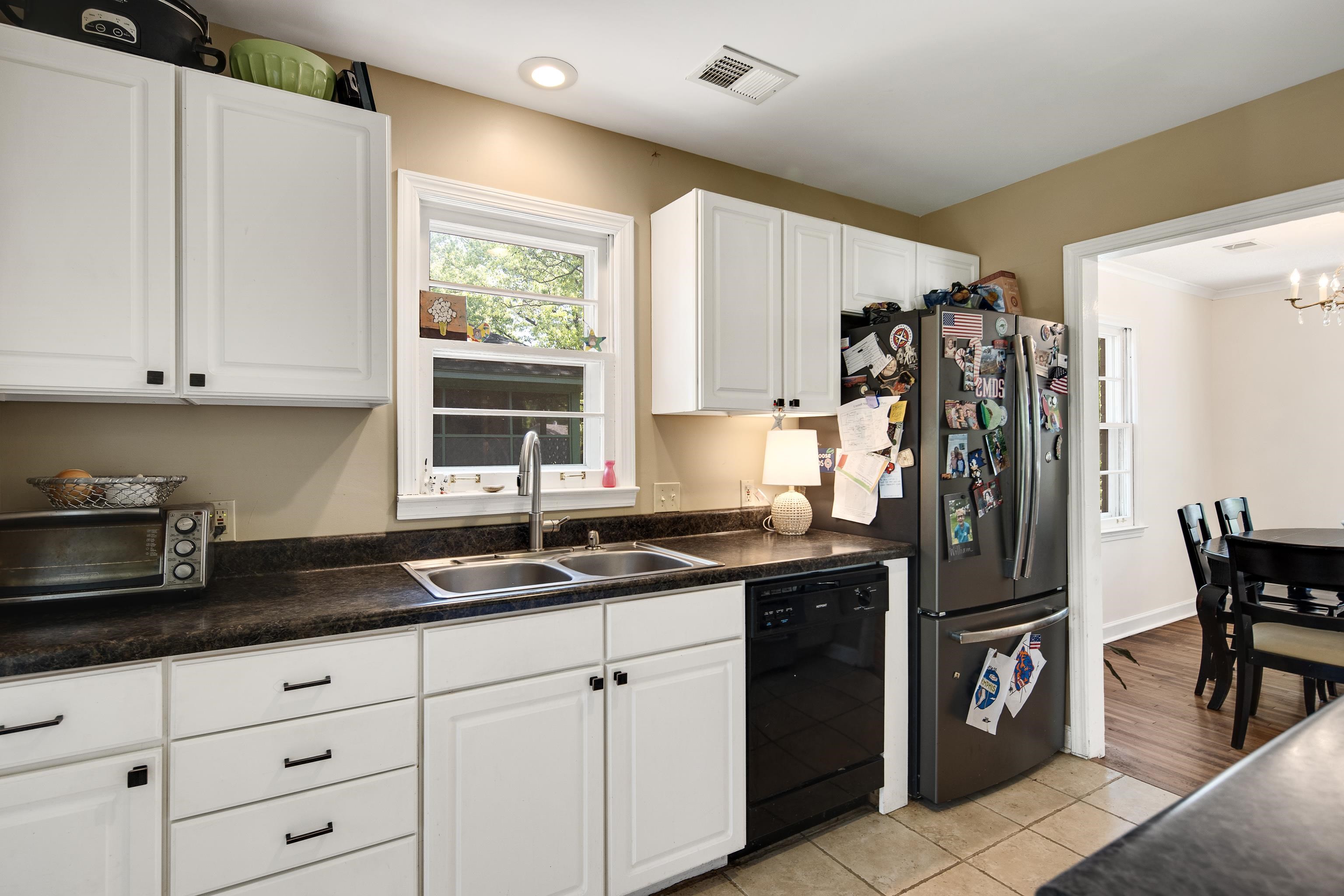 4566 Amboy Road Memphis, TN 38117 - Photo 15 of 29 a kitchen with granite countertop a refrigerator a sink a stove and white cabinets
