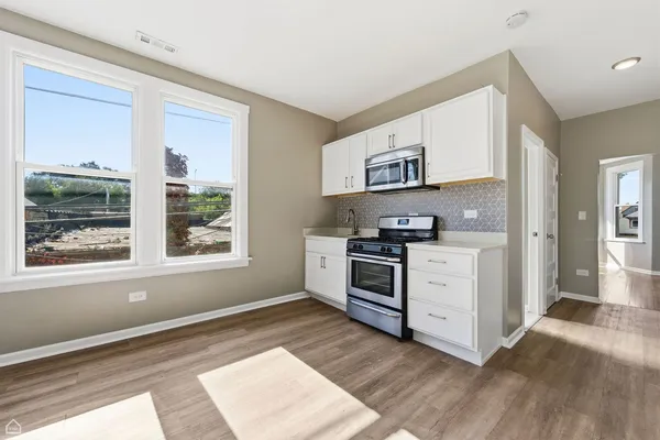 a kitchen with granite countertop a stove a sink and a refrigerator