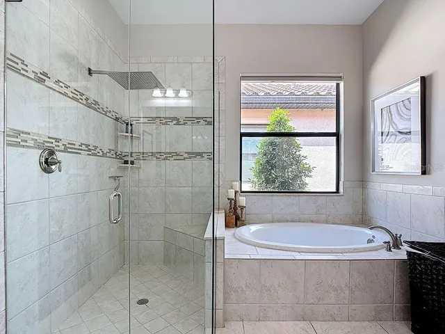 a spacious bathroom with a granite countertop tub sink shower and mirror