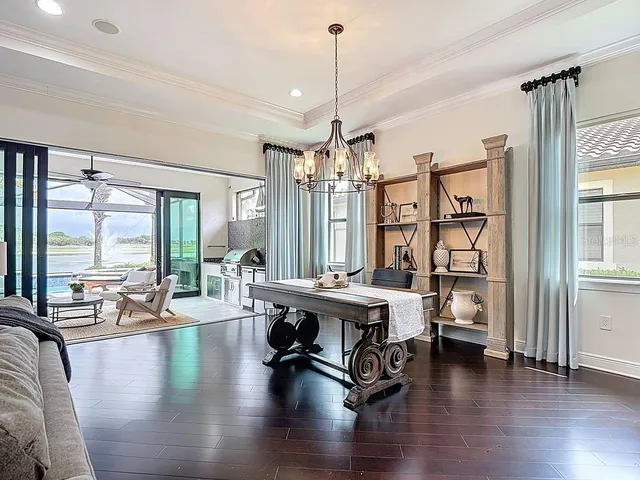 a living room with furniture floor to ceiling window and wooden floor
