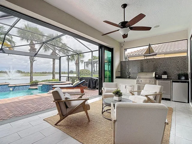 a living room with furniture ceiling fan and a large window