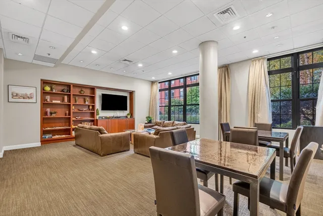 a living room with furniture a flat screen tv and floor to ceiling window