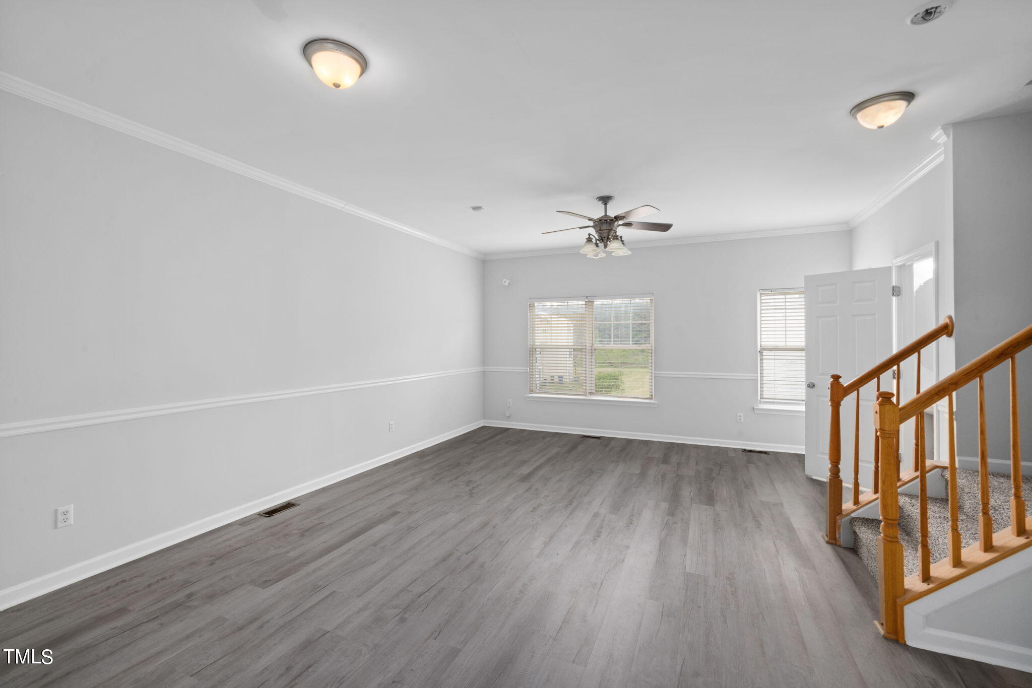 1237 Stone Manor Drive Raleigh, NC 27610 - Photo 11 of 29 an empty room with wooden floor fan and windows
